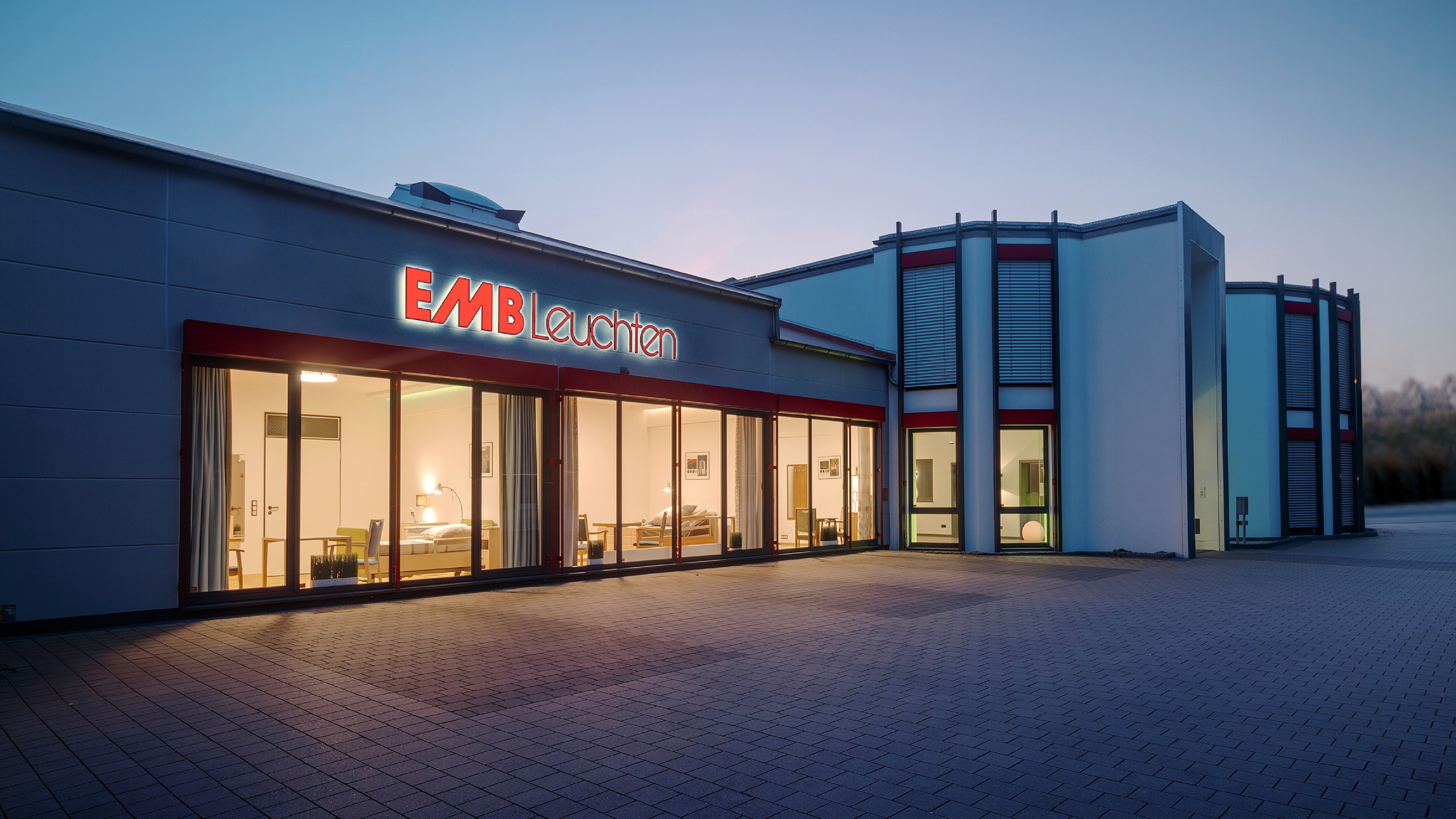 EMB Leuchten Gebäude bei Abendlicht